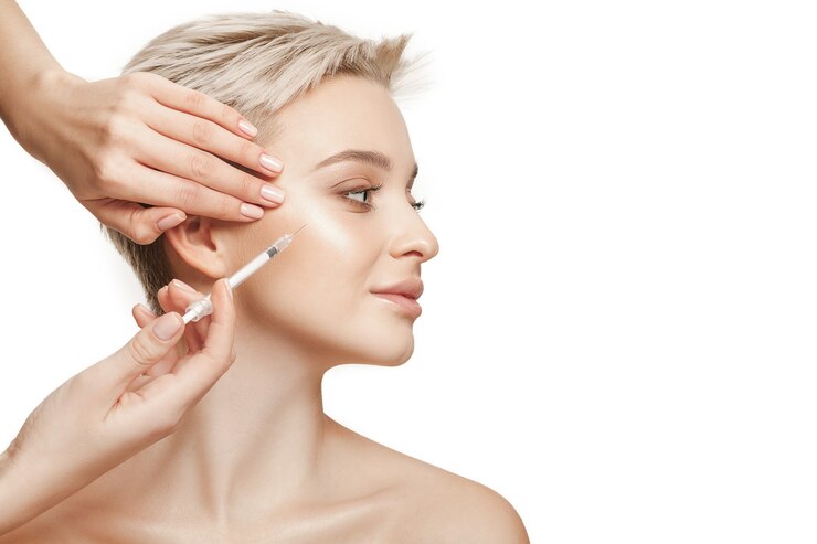 beautiful young woman face and hand with syringe making injection