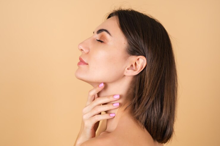 Portrait of a young woman on beige with natural makeup, with a light sensual smile, bare shoulders, beauty face, advertising of cosmetics and care